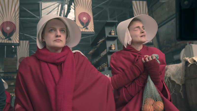 June (Elisabeth Moss) and Janine (Madeline Brewer) watch helplessly as an ambulance passes the market.